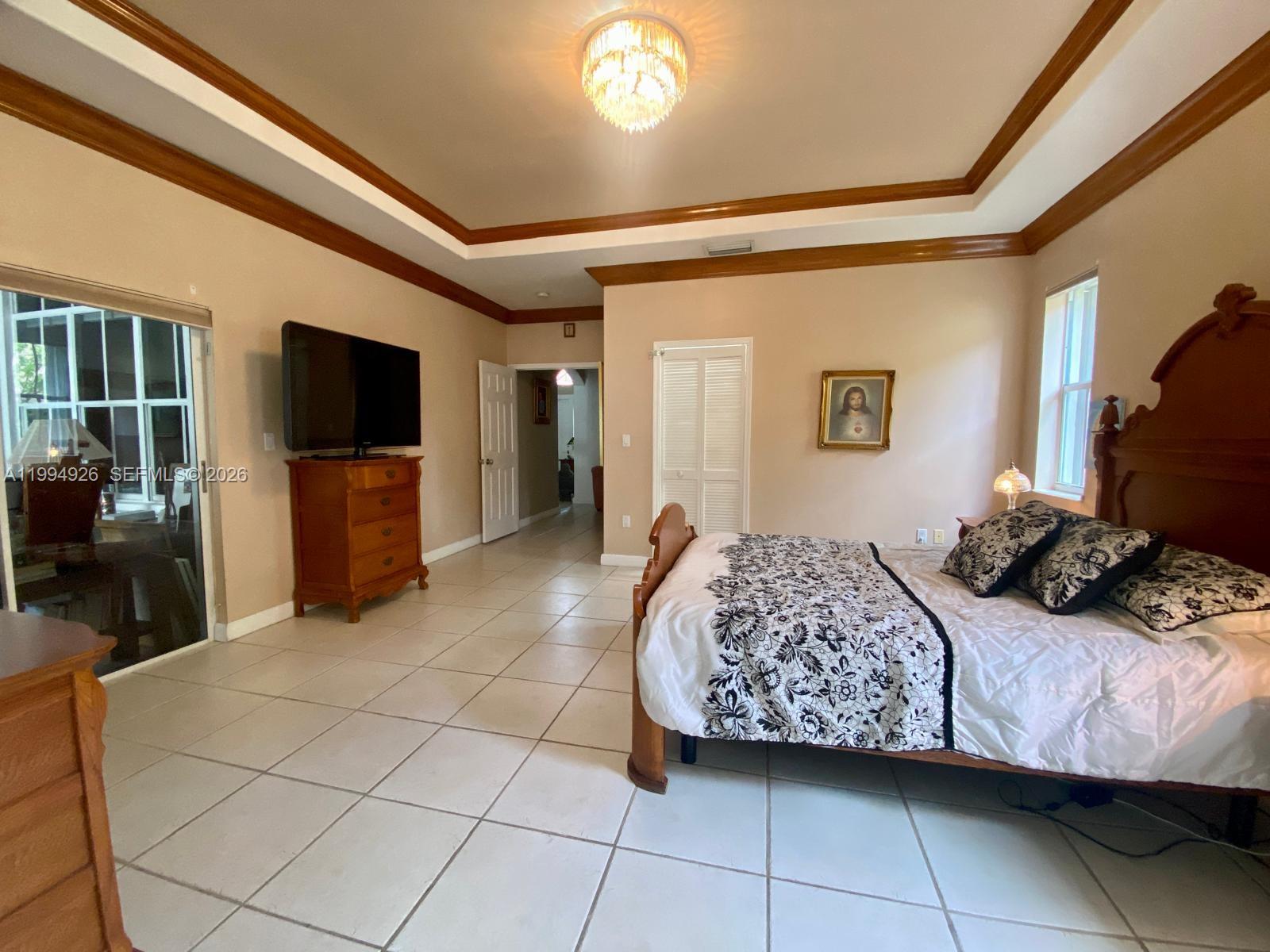 656 Northwest 129th Place Miami, FL 33182 - Photo 11 of 36 a bedroom with a bed and a flat screen tv