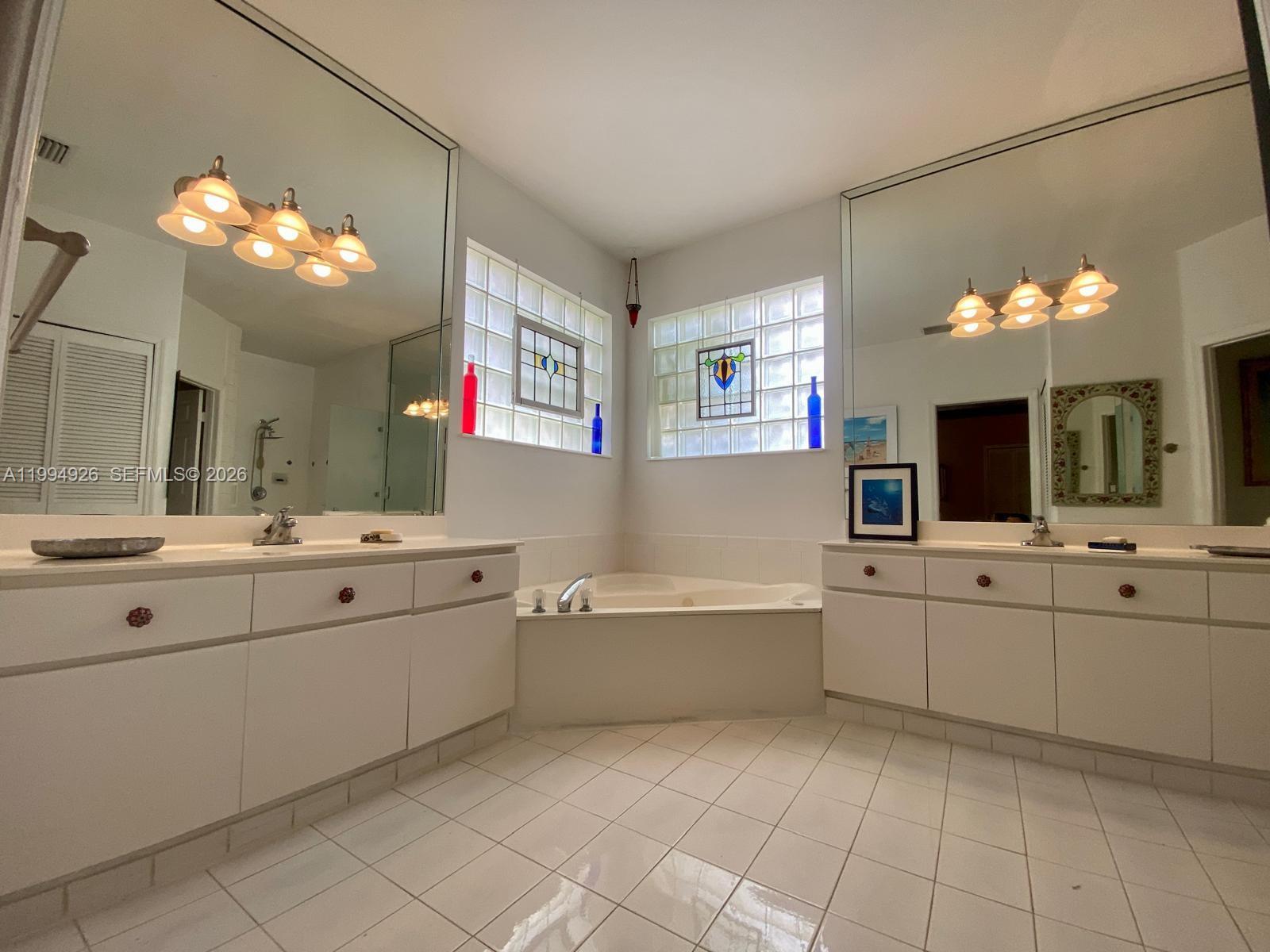 656 Northwest 129th Place Miami, FL 33182 - Photo 12 of 36 a large bathroom with a sink mirror and a bathtub