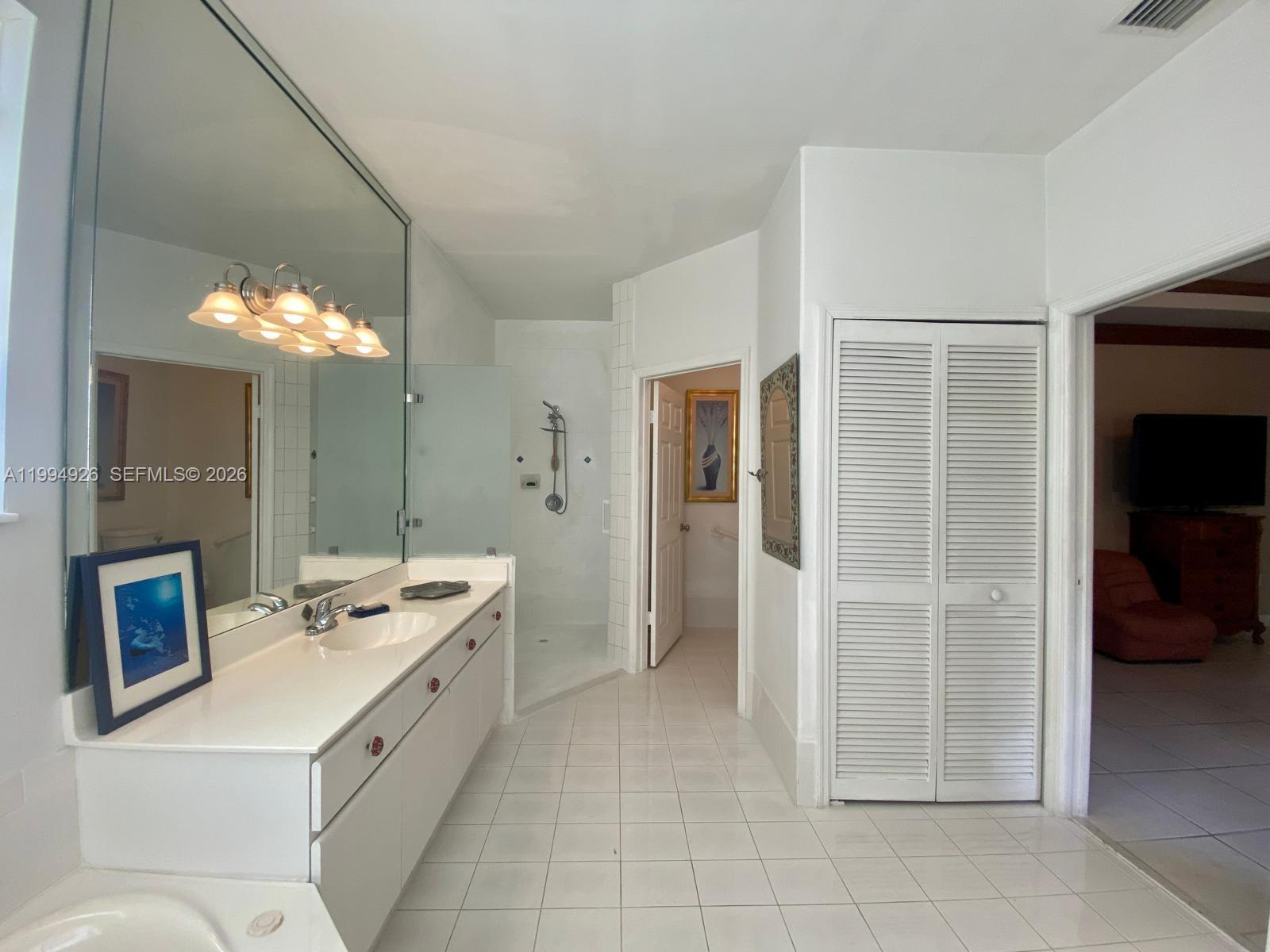 656 Northwest 129th Place Miami, FL 33182 - Photo 13 of 36 a bathroom with a double vanity sink and a mirror