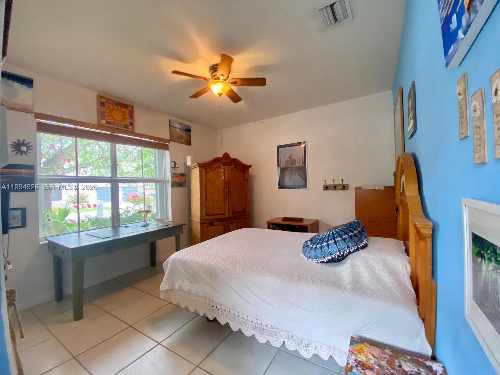 656 Northwest 129th Place Miami, FL 33182 - Photo 16 of 36 a bedroom with a bed and a chandelier