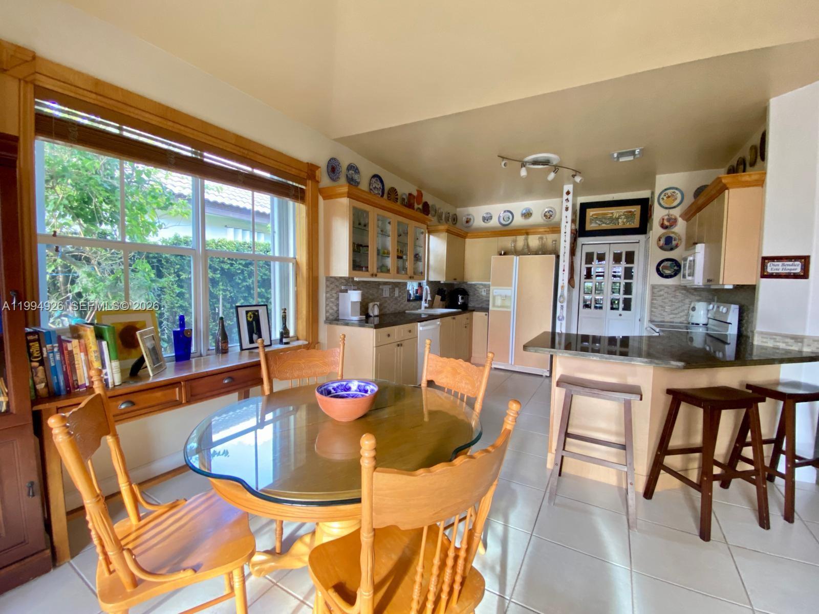 656 Northwest 129th Place Miami, FL 33182 - Photo 22 of 36 a dining room with furniture a kitchen view and a faucet