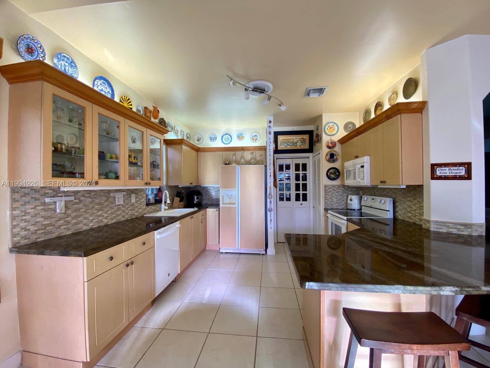 656 Northwest 129th Place Miami, FL 33182 - Photo 23 of 36 a large kitchen with stainless steel appliances a large counter top a stove and a refrigerator