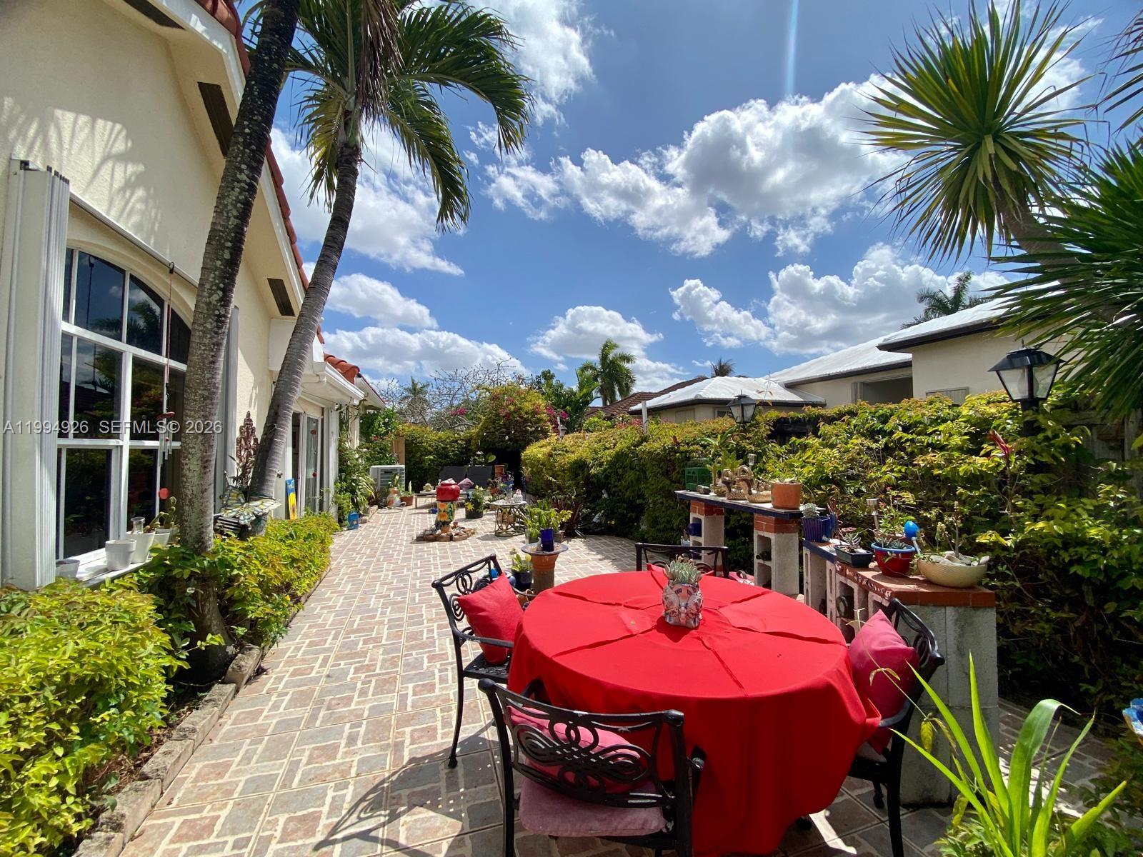 656 Northwest 129th Place Miami, FL 33182 - Photo 31 of 36 a view of a patio with table and chairs potted plants