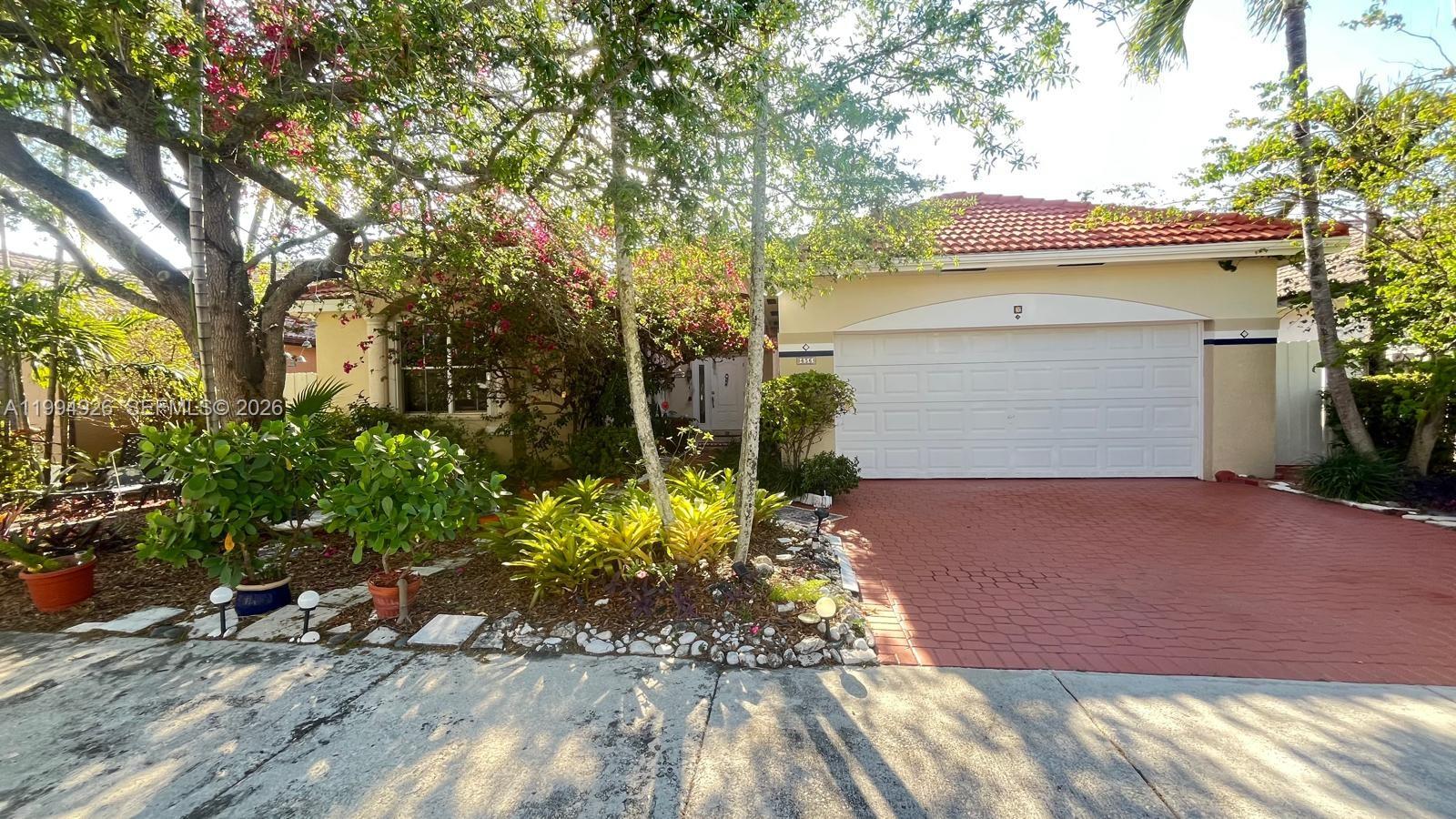 656 Northwest 129th Place Miami, FL 33182 - Photo 36 of 36 a front view of a house with a yard and a garage