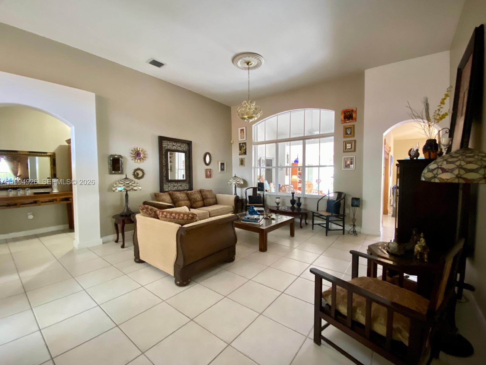 656 Northwest 129th Place Miami, FL 33182 - Photo 5 of 36 a living room with furniture a flat screen tv and a large window