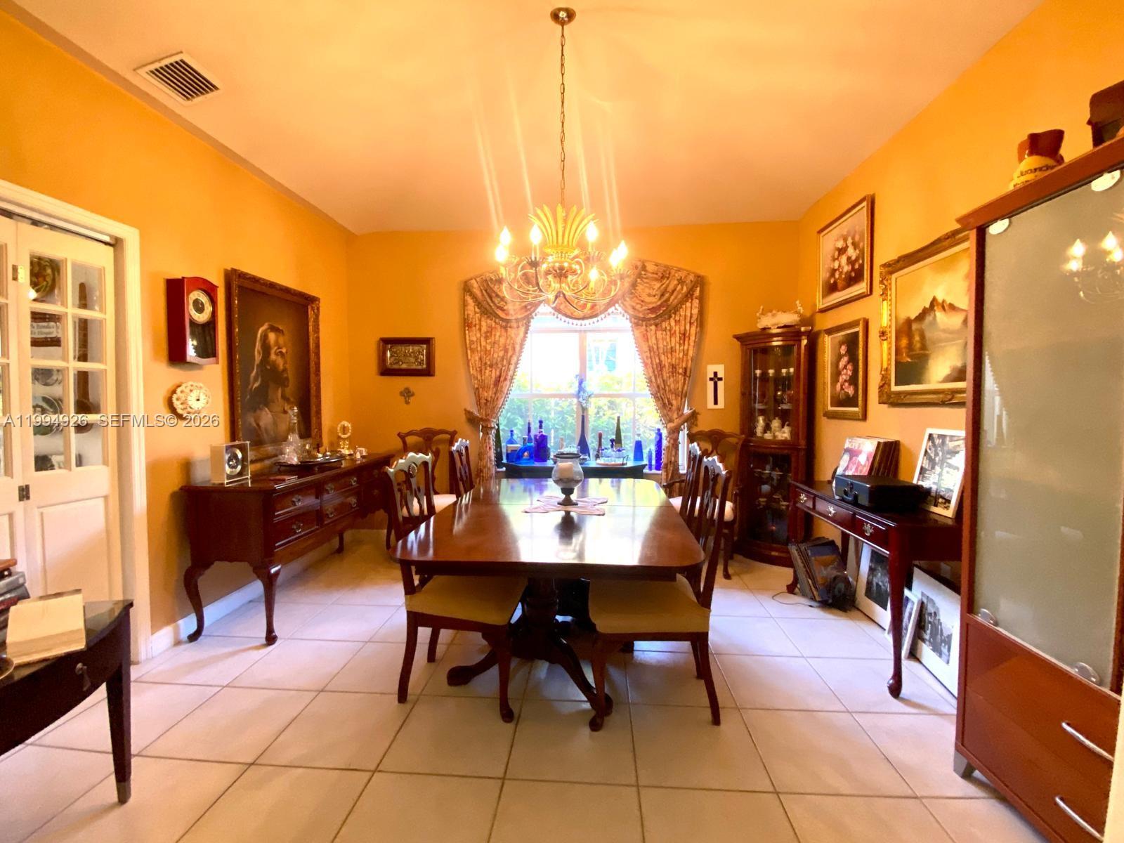 656 Northwest 129th Place Miami, FL 33182 - Photo 8 of 36 a view of a dining room with furniture and chandelier
