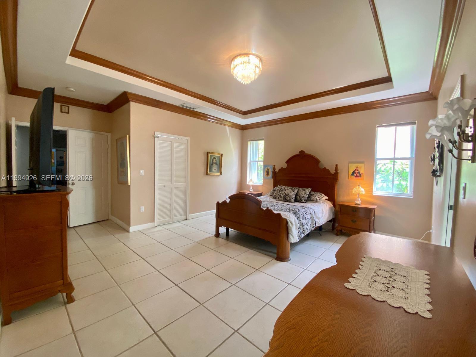 656 Northwest 129th Place Miami, FL 33182 - Photo 10 of 36 a spacious bedroom with a bed and a couch