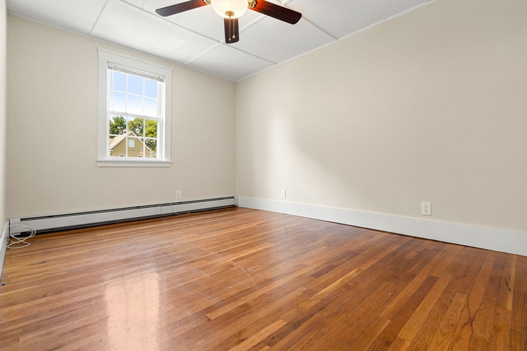 12 Chestnut Street Danvers, MA 01923 - Photo 29 of 37 an empty room with wooden floor chandelier fan and windows