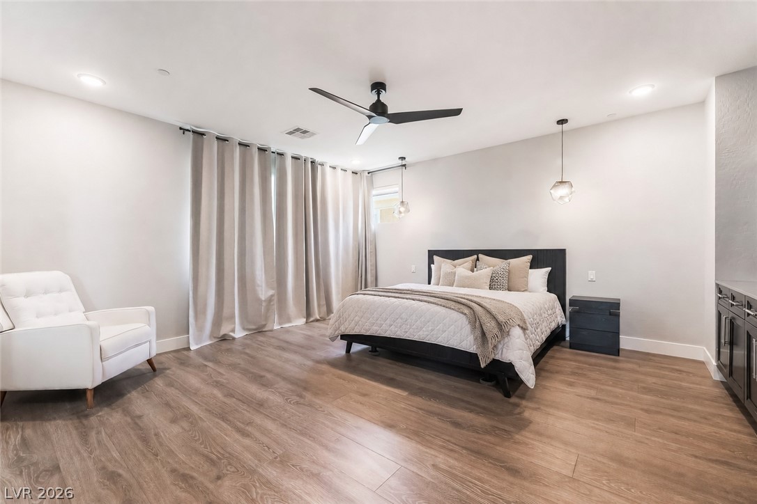 2166 Trivero Street Henderson, NV 89044 - Photo 25 of 61 Well-lit sleeping quarters with rich wood flooring and subtle recessed lighting.