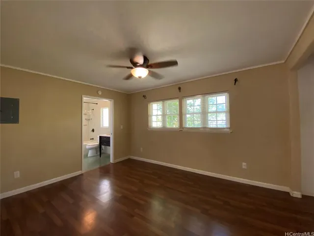 a view of an empty room with a window and wooden floor