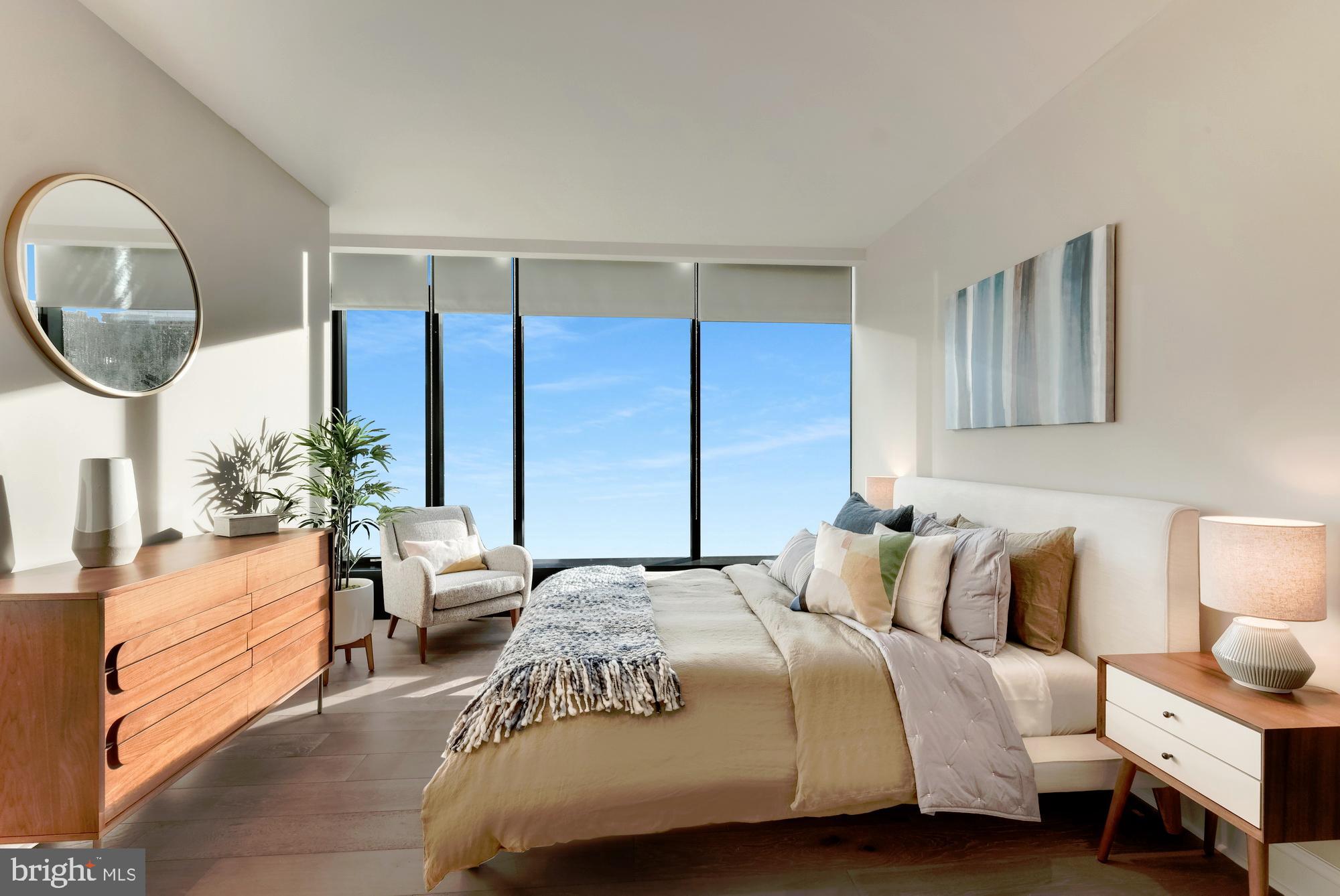 30 North 23rd Street, Unit 2008 Philadelphia, PA 19103 - Photo 16 of 42 a bedroom with a bed a mirror and a large window