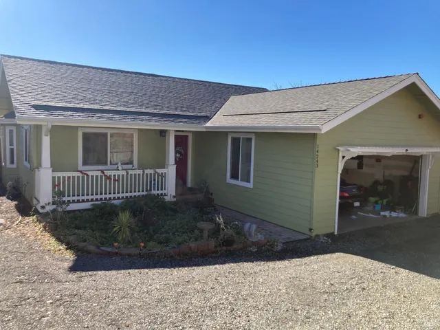 a view of a house with a yard and potted plants