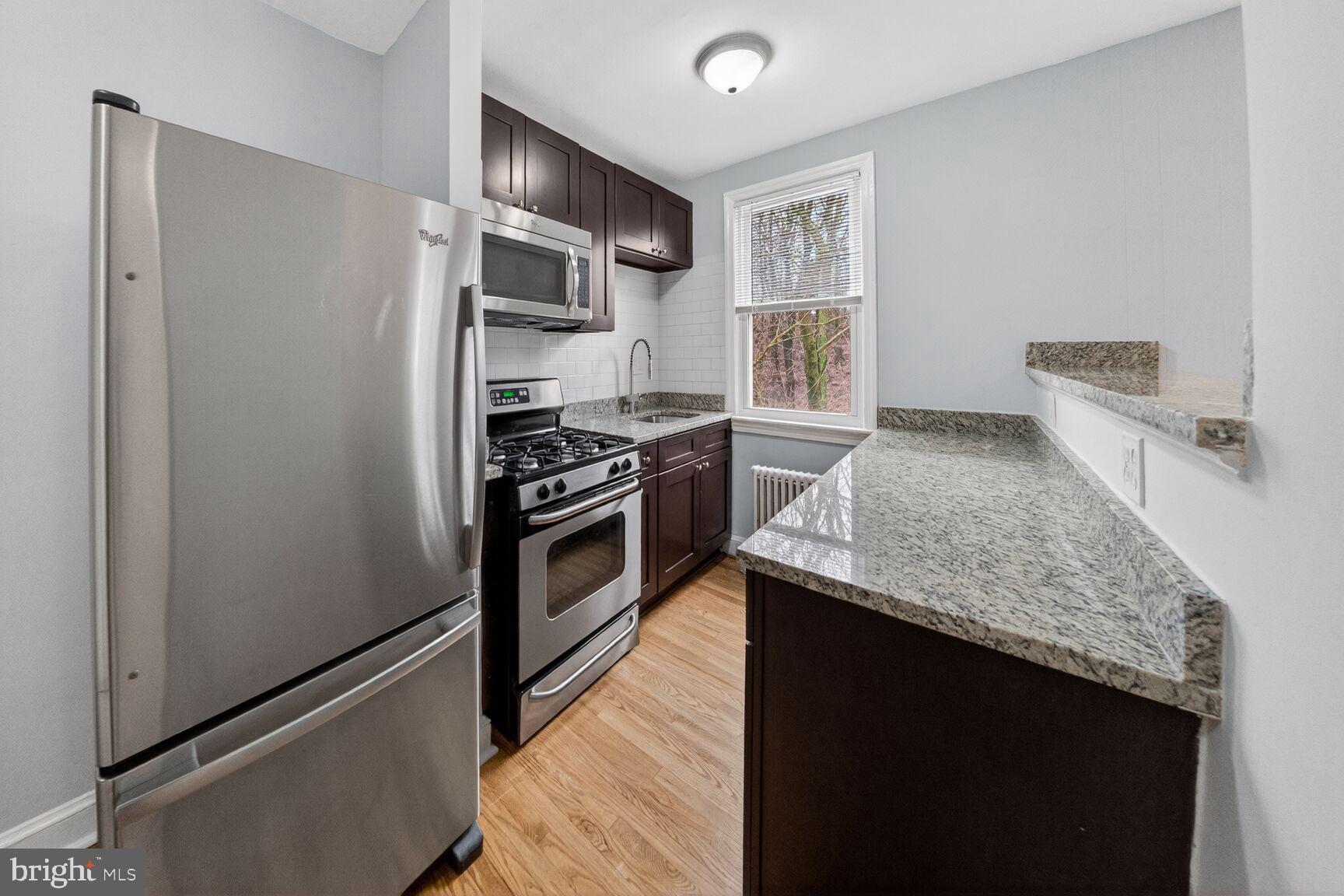 4703 Ravenswood Road, Unit 25 Riverdale, MD 20737 - Photo 7 of 12 a kitchen with stainless steel appliances granite countertop a refrigerator and a stove