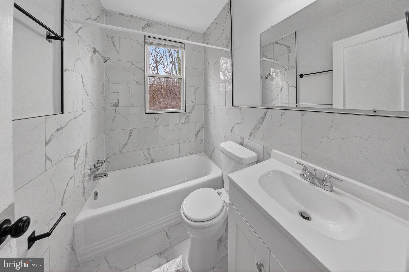 4703 Ravenswood Road, Unit 25 Riverdale, MD 20737 - Photo 9 of 12 a bathroom with a sink toilet and shower