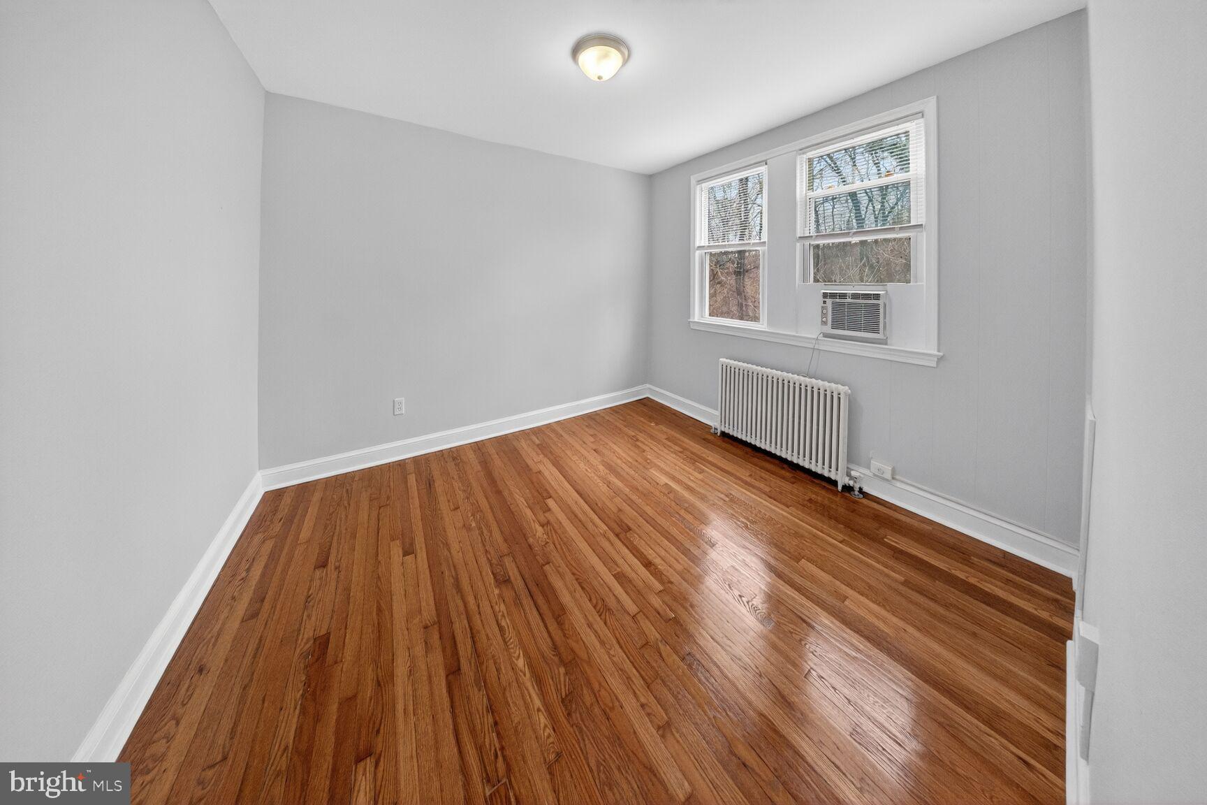 4703 Ravenswood Road, Unit 25 Riverdale, MD 20737 - Photo 10 of 12 a view of an empty room with wooden floor and a window