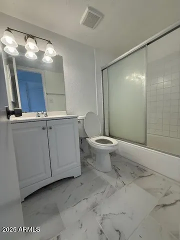 a bathroom with a granite countertop sink mirror and toilet