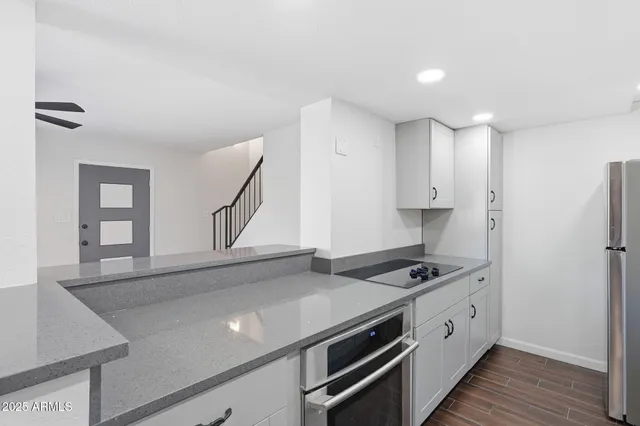 a kitchen with stainless steel appliances a sink cabinets and wooden floor