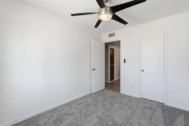 an empty room with a ceiling fan and a ceiling fan