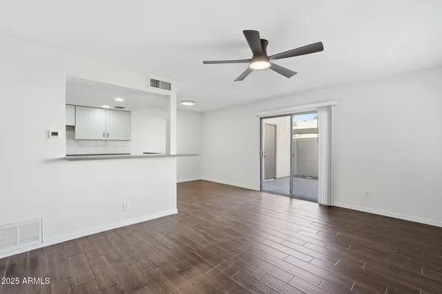 a view of a livingroom with a ceiling fan & wooden floor