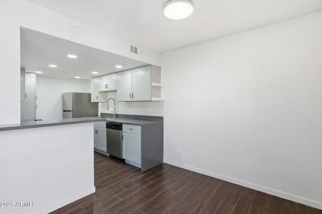 a kitchen with a refrigerator and a stove top oven