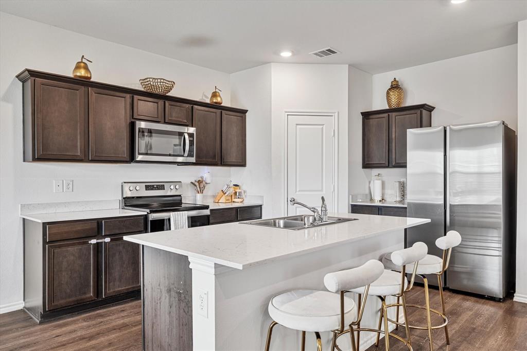 1231 Delmita Drive Forney, TX 75126 - Photo 13 of 38 a kitchen with stainless steel appliances a stove refrigerator sink and microwave