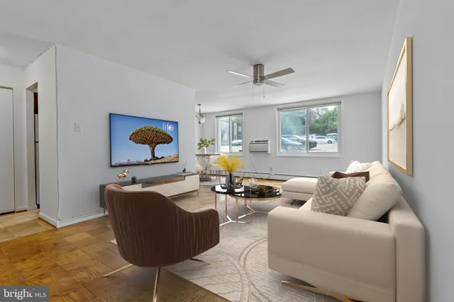 a living room with furniture wooden floor and a window