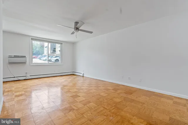 an empty room with windows and ceiling fan
