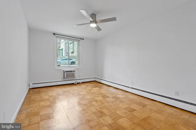 an empty room with windows and fan