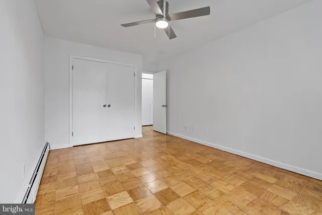 an empty room with a ceiling fan and carpet