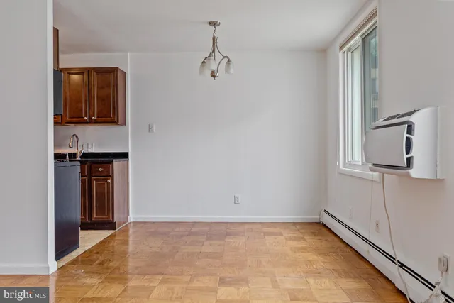 a view of a hallway with wooden floor and cabinets