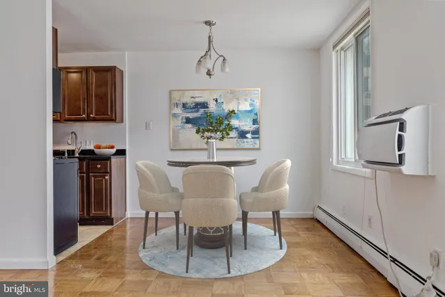 a dining room with wooden floor a chandelier a wooden table and chairs