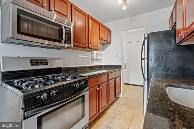 a kitchen with stainless steel appliances granite countertop a stove microwave and refrigerator