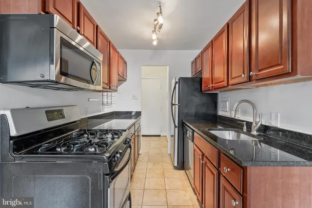 a kitchen with stainless steel appliances granite countertop a stove and a sink