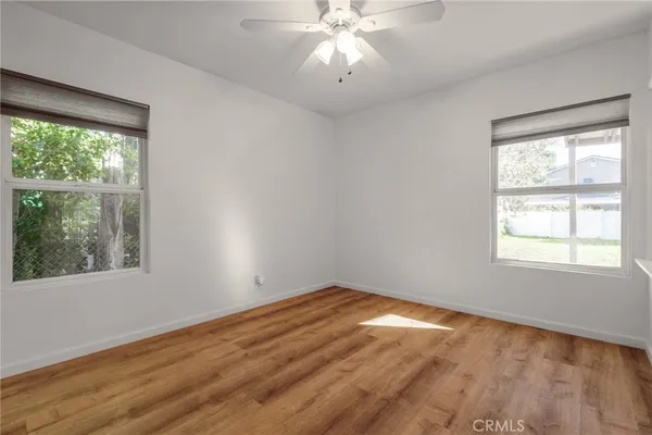 an empty room with a window and wooden floor