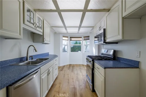 a kitchen with stainless steel appliances granite countertop a sink stove and cabinets