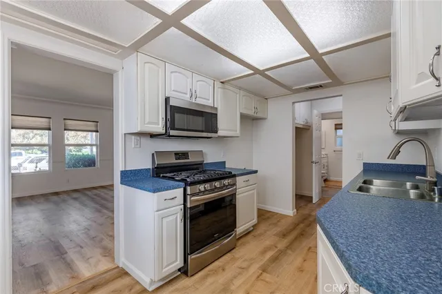 a kitchen with stainless steel appliances granite countertop a stove a sink and a refrigerator