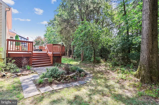 a view of a house with a big yard and large trees
