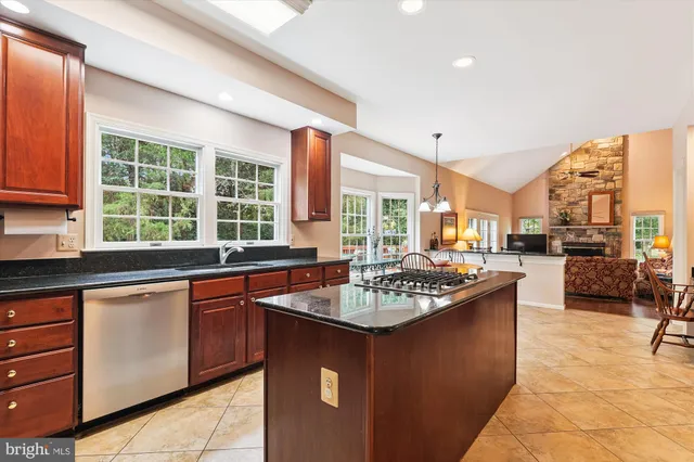a kitchen with kitchen island granite countertop a sink stove and cabinets