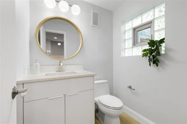 a bathroom with a toilet a sink and a mirror