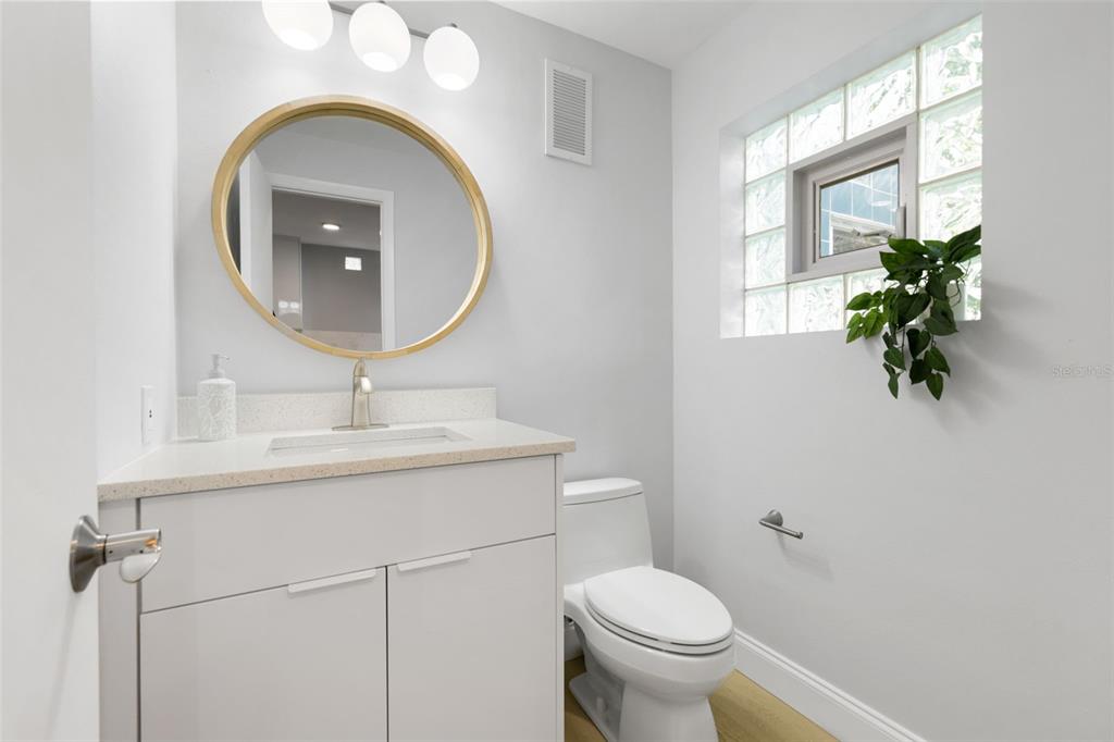 4950 Bayshore Boulevard, Unit 23 Tampa, FL 33611 - Photo 11 of 40 a bathroom with a toilet a sink and a mirror