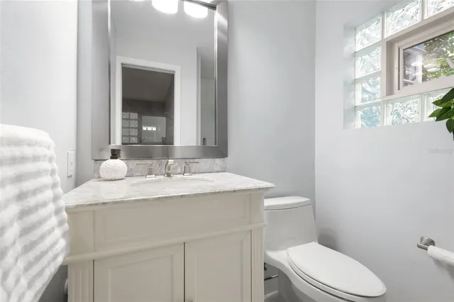 a bathroom with a sink vanity mirror and toilet
