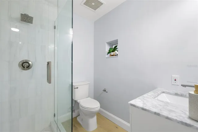 a bathroom with a granite countertop sink a toilet and shower