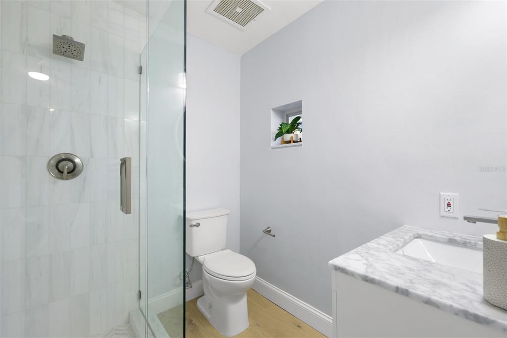 4950 Bayshore Boulevard, Unit 23 Tampa, FL 33611 - Photo 20 of 40 a bathroom with a granite countertop sink a toilet and shower