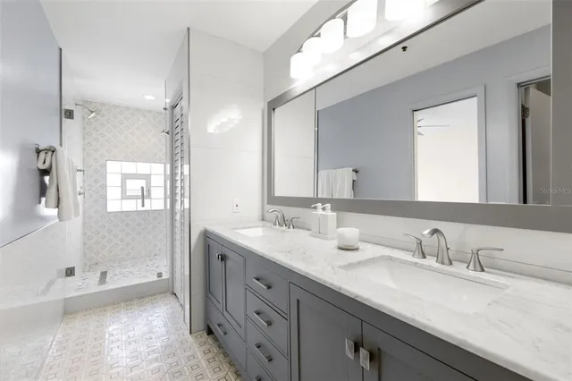 a bathroom with a granite countertop sink mirror and a bathtub