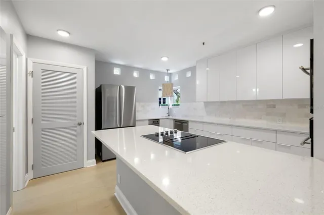 a kitchen with refrigerator and a sink