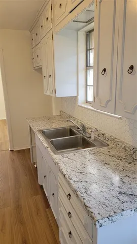 a view of a kitchen with a sink a faucet and a stove