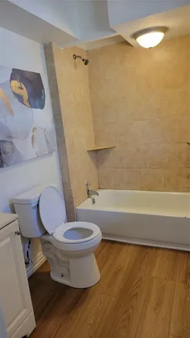 a white toilet sitting next to a bath tub and a shower