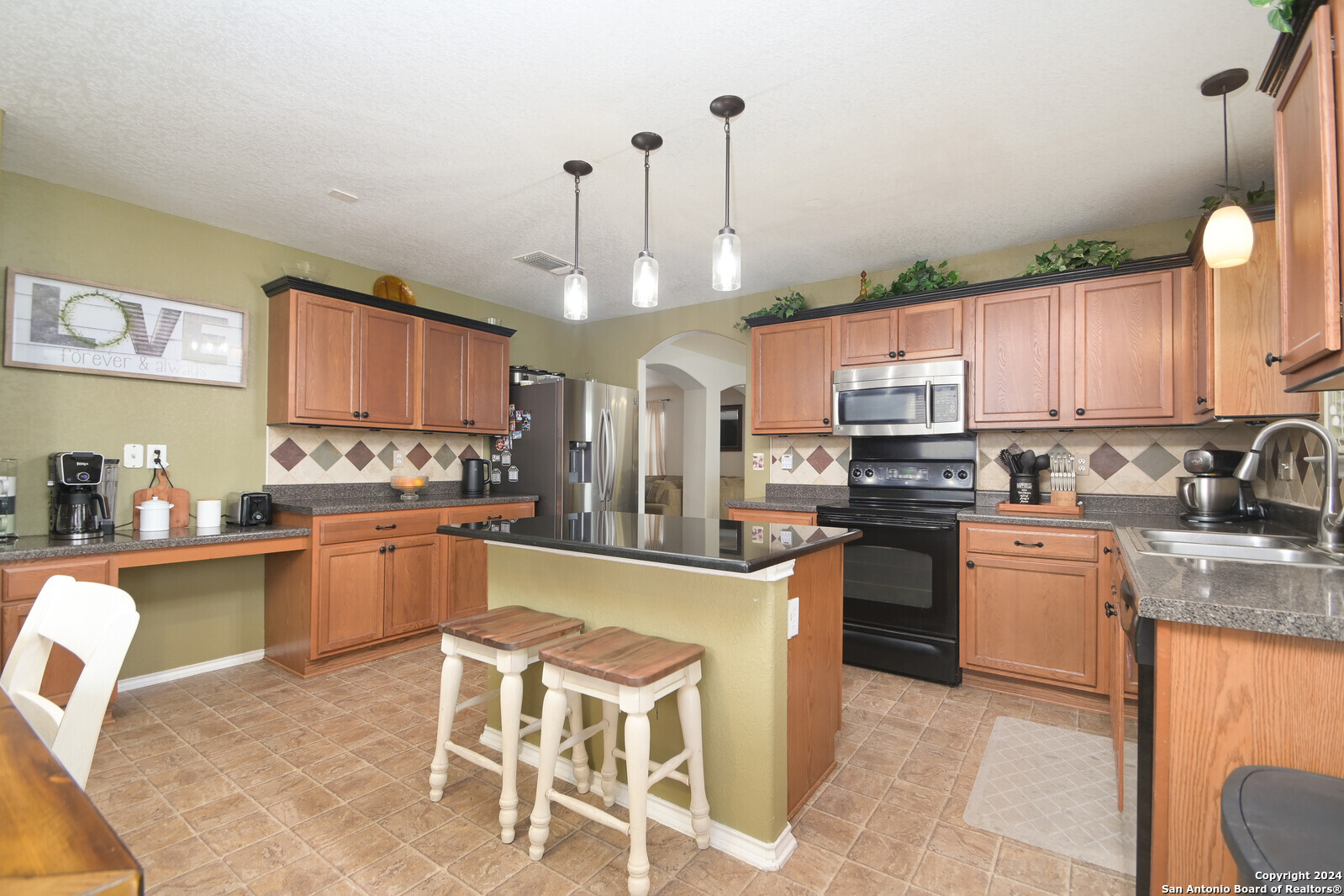 a kitchen with stainless steel appliances granite countertop a stove top oven a sink dishwasher and white cabinets