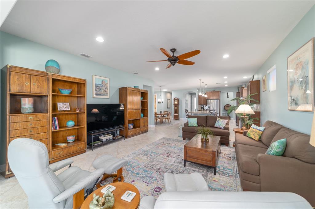 10106 Southwest 77th Loop Ocala, FL 34481 - Photo 13 of 69 a living room with furniture and a flat screen tv with kitchen view