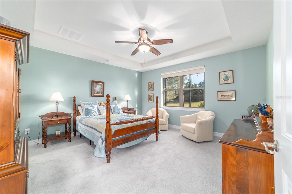 10106 Southwest 77th Loop Ocala, FL 34481 - Photo 30 of 69 a bed room with furniture and a chandelier